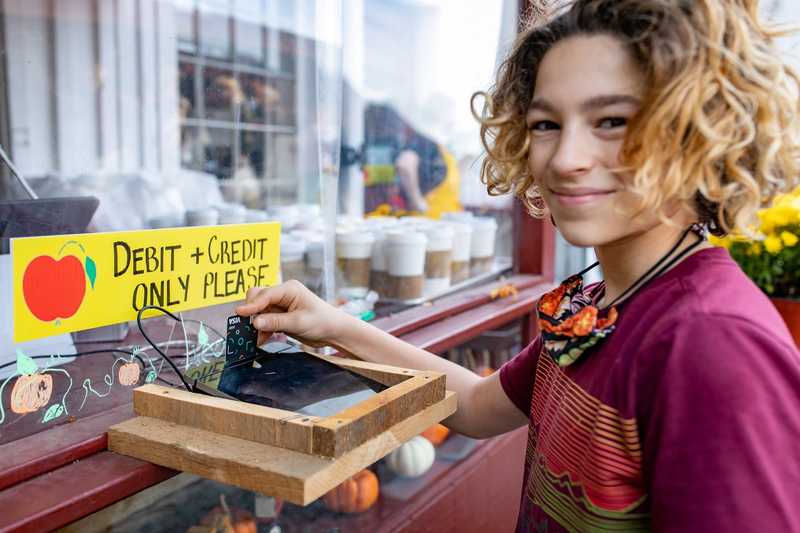 Teenager using a Till debit card to make a purchase at a coffee shop