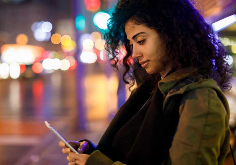 A young lady using her cellphone in the city