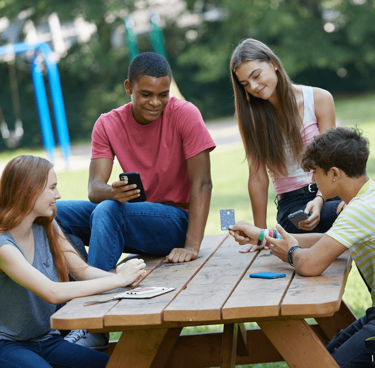 Group of four students looking at the Till card that one of them is holding in his hands