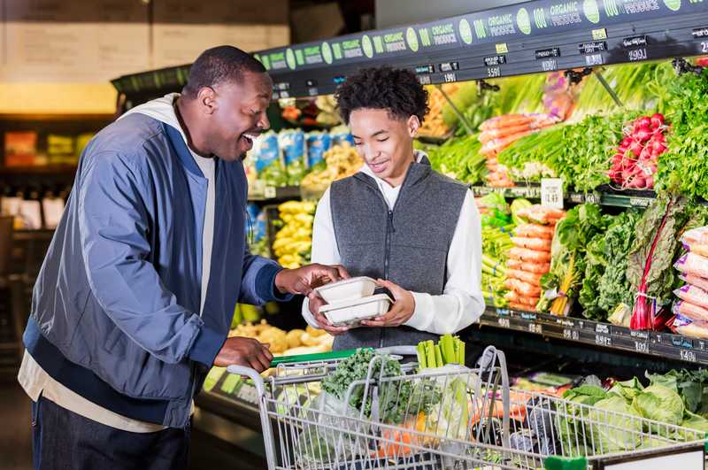 Father and Son laughing while grocery shopping together